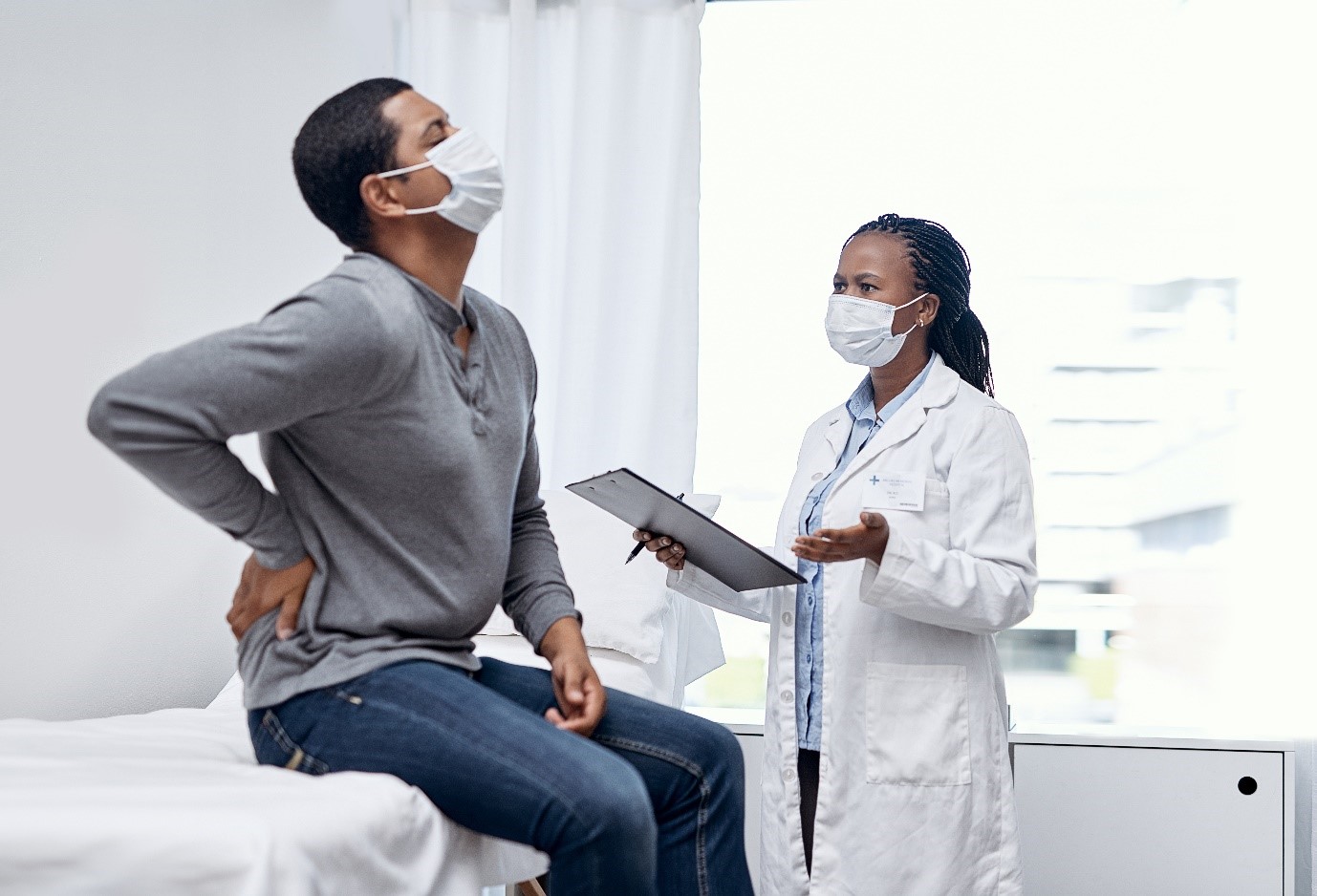 Image showing the doctor having a consultation with a patient suffering from back pain.